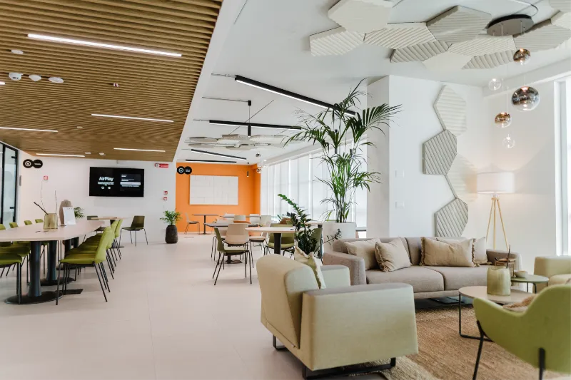 Clubhouse luminosa con aree lounge e tavoli condivisi