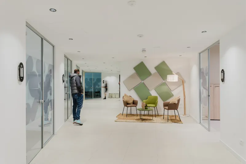 Corridoio luminoso con accessi agli uffici e area di attesa